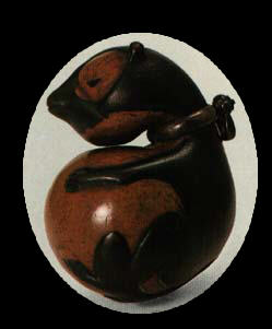 Tanuki carvings, like this netsuke, are popular and cute, with the rounded contours of teddy bears. This one is an old antique. Artist and photographer are unknown.